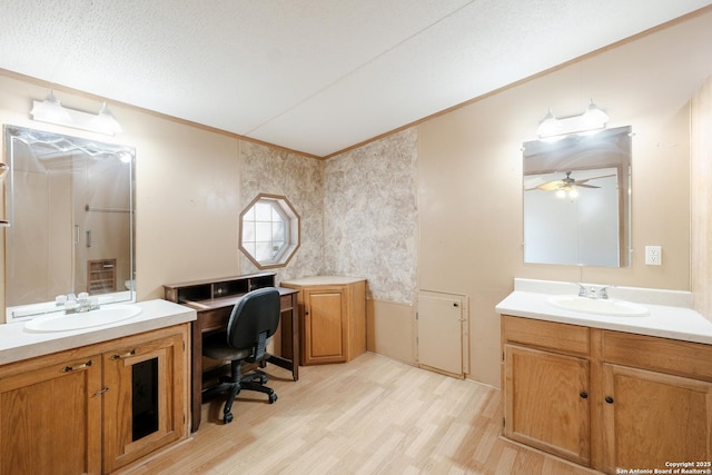 bathroom with ceiling fan, hardwood / wood-style floors, vanity, and a textured ceiling