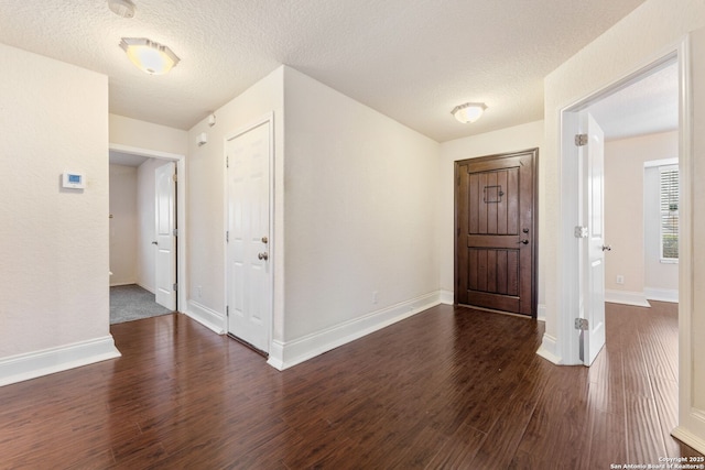 entryway with a textured ceiling and dark wood-type flooring