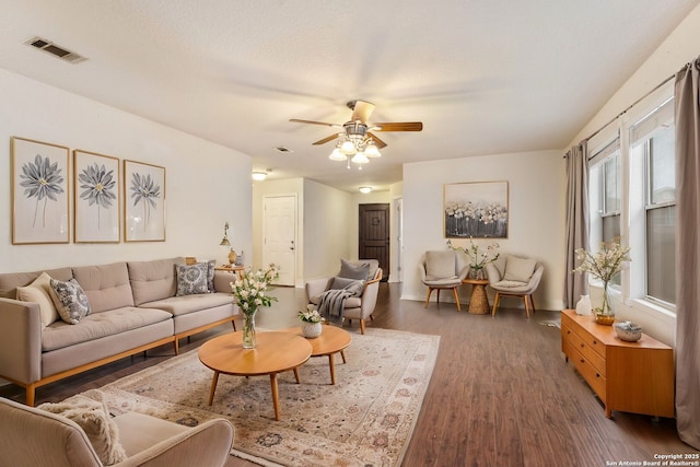 living room featuring a textured ceiling, ceiling fan, and dark hardwood / wood-style floors