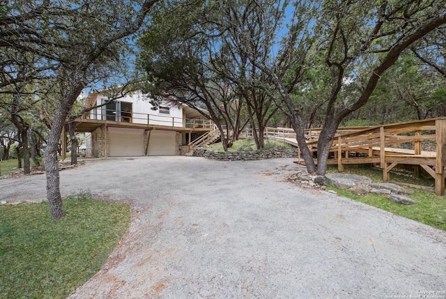 view of front of house with a wooden deck, a balcony, and a garage