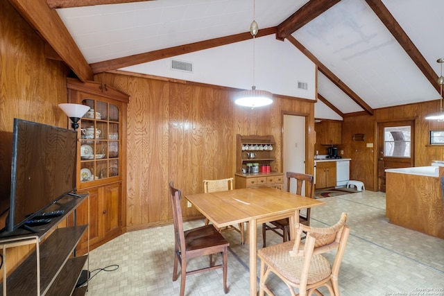 dining room featuring wood walls and lofted ceiling with beams