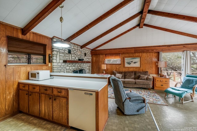 kitchen featuring high vaulted ceiling, kitchen peninsula, fridge, decorative light fixtures, and wooden walls