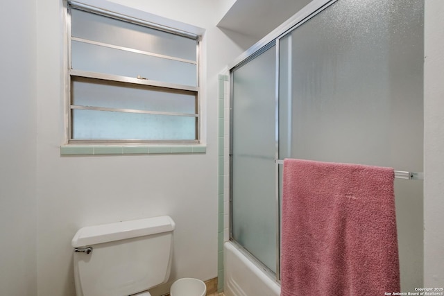 bathroom featuring shower / bath combination with glass door and toilet