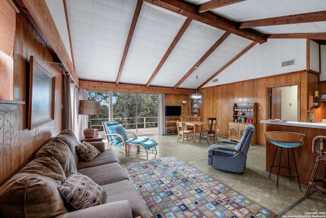 living room featuring beam ceiling, high vaulted ceiling, and wooden walls