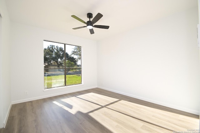 spare room with hardwood / wood-style floors, ceiling fan, and a healthy amount of sunlight