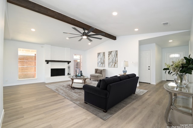 living room featuring ceiling fan, plenty of natural light, lofted ceiling with beams, and light wood-type flooring