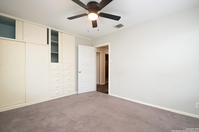 unfurnished bedroom with dark colored carpet and ceiling fan