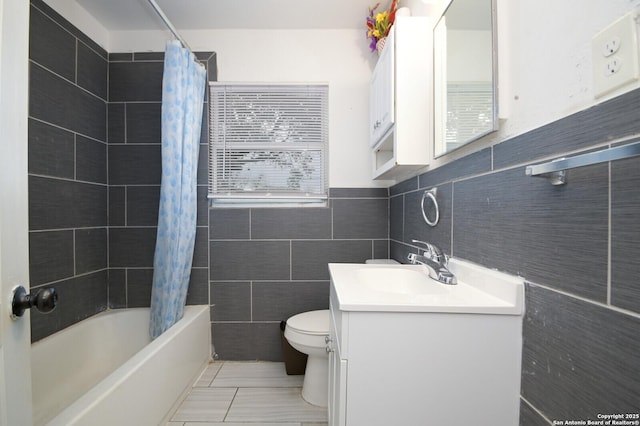 full bathroom with shower / bath combo, tile patterned flooring, toilet, vanity, and tile walls