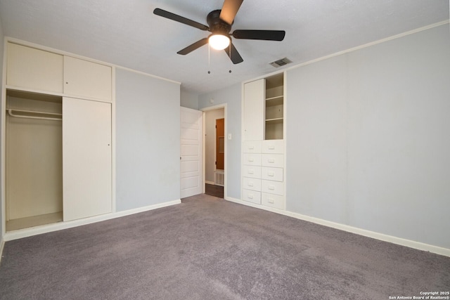 unfurnished bedroom featuring dark carpet and ceiling fan