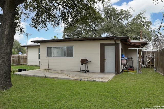 rear view of property featuring a patio area and a yard