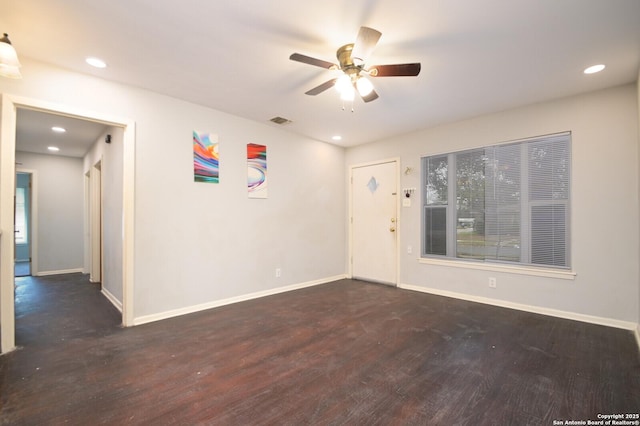 spare room featuring ceiling fan and dark wood-type flooring