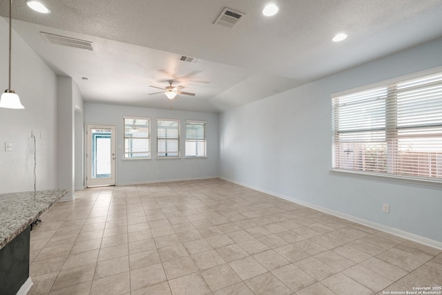 tiled spare room featuring a wealth of natural light, a textured ceiling, ceiling fan, and lofted ceiling