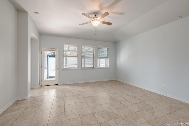 tiled empty room featuring ceiling fan and vaulted ceiling