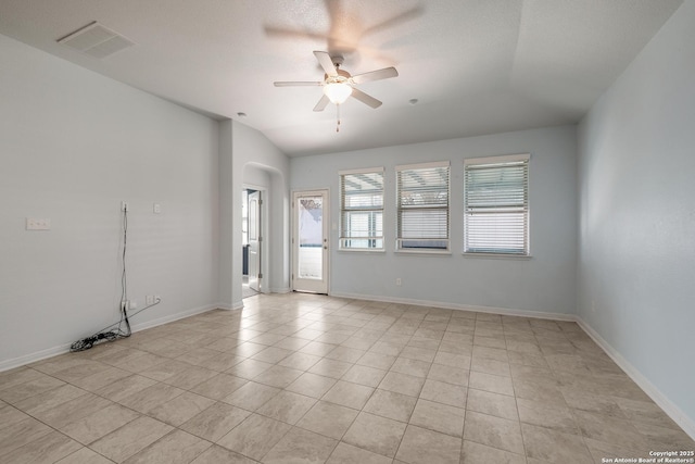 spare room with ceiling fan, light tile patterned floors, and vaulted ceiling