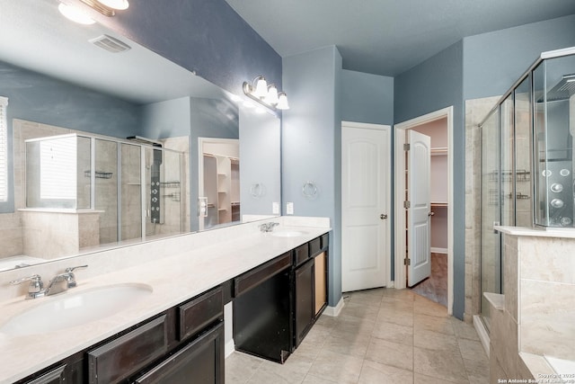 bathroom with tile patterned floors, vanity, and walk in shower