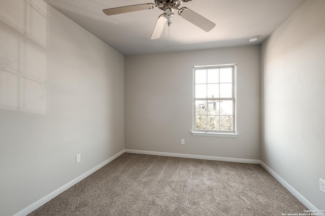 carpeted spare room featuring ceiling fan