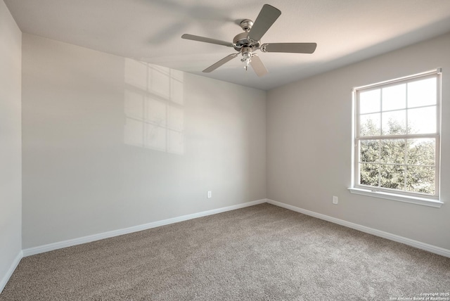 carpeted empty room with ceiling fan and a wealth of natural light