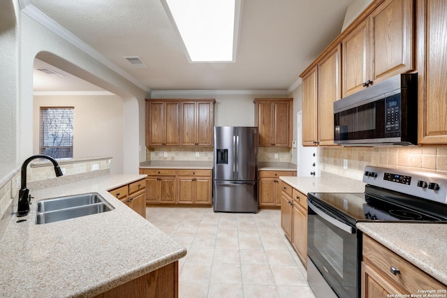 kitchen featuring sink, stainless steel appliances, backsplash, crown molding, and light tile patterned floors