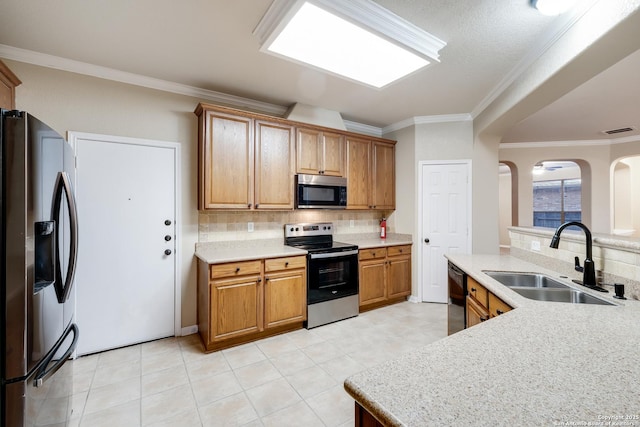 kitchen featuring tasteful backsplash, sink, ornamental molding, and appliances with stainless steel finishes