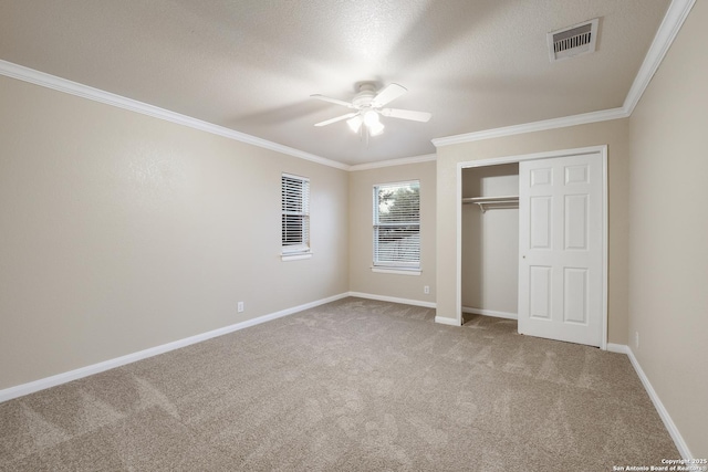 unfurnished bedroom with carpet floors, a closet, ceiling fan, and ornamental molding