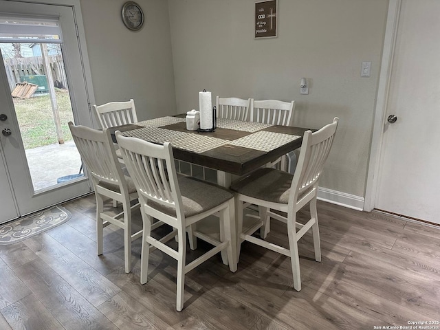 dining space with hardwood / wood-style floors and a healthy amount of sunlight