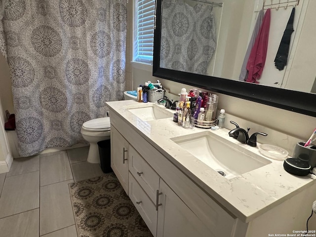 bathroom with tile patterned flooring, vanity, and toilet