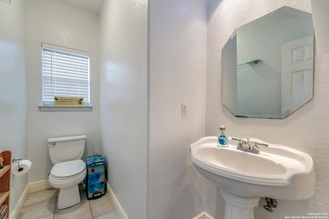 bathroom featuring tile patterned flooring, toilet, and sink