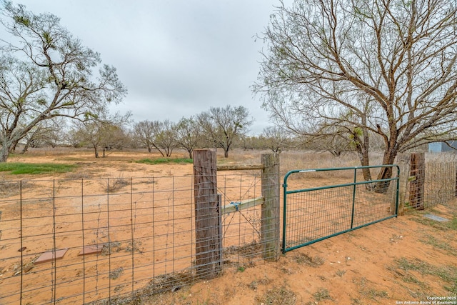 view of gate with a rural view