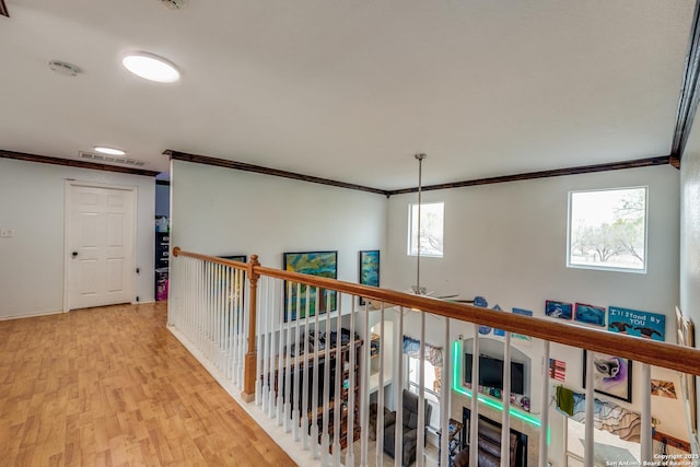 hallway with crown molding and light wood-type flooring