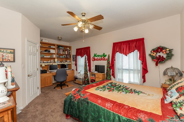 bedroom featuring carpet, built in desk, and ceiling fan