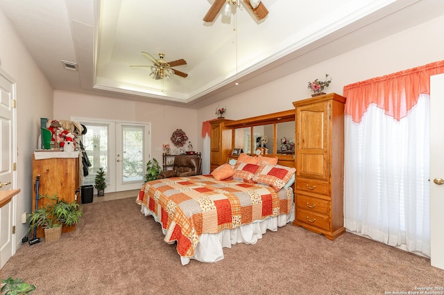 carpeted bedroom with ceiling fan, a tray ceiling, and access to outside