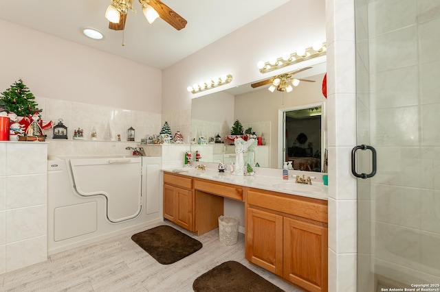 bathroom with vanity, hardwood / wood-style floors, ceiling fan, and walk in shower