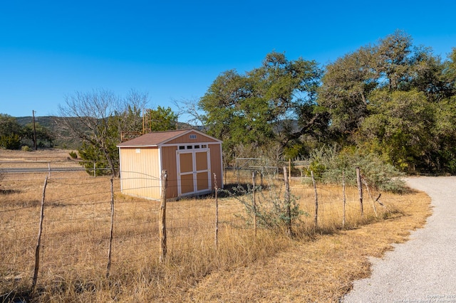 view of yard with a storage shed and a rural view