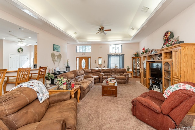 carpeted living room featuring ceiling fan and a tray ceiling