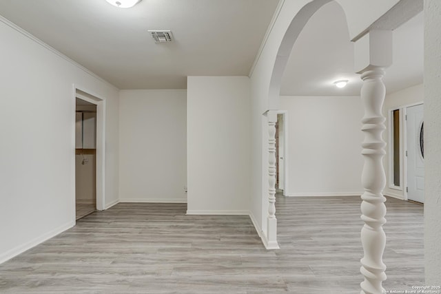 hallway with light hardwood / wood-style floors and crown molding