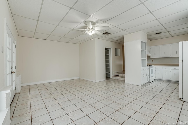 unfurnished living room featuring light tile patterned floors, a drop ceiling, and ceiling fan