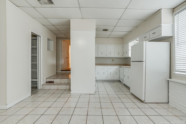 kitchen featuring white appliances, white cabinetry, and a paneled ceiling