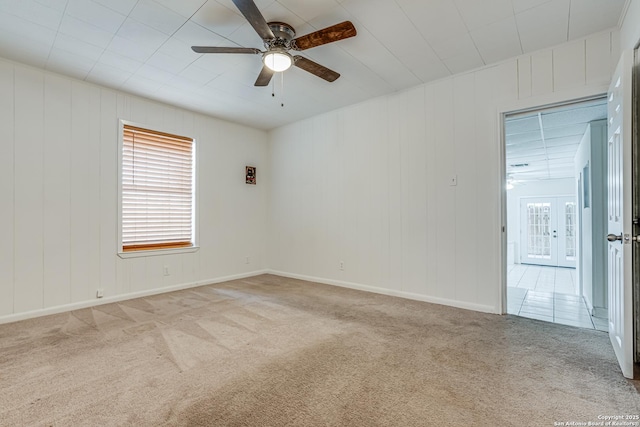 spare room with french doors, light colored carpet, and ceiling fan