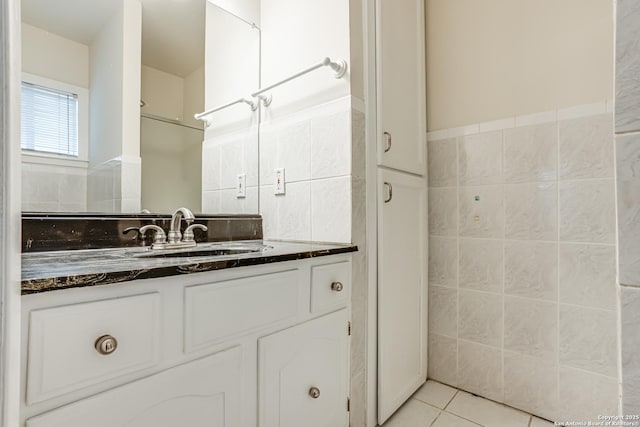 bathroom featuring tile patterned flooring, vanity, and tile walls