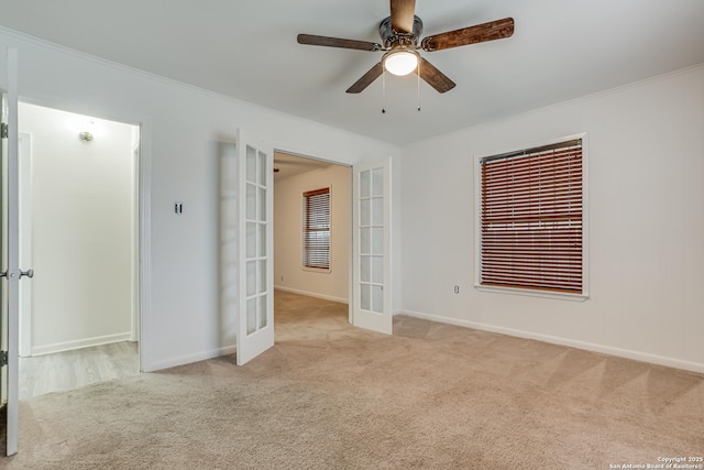 carpeted empty room with ceiling fan and french doors