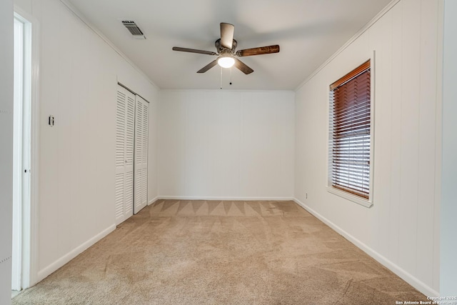 unfurnished bedroom with ceiling fan, ornamental molding, and light carpet