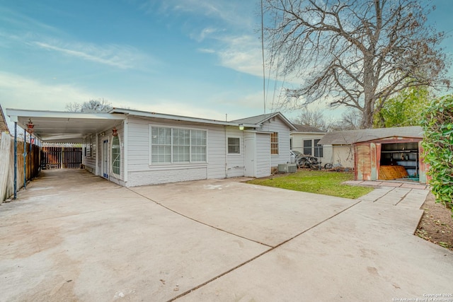 rear view of property featuring a yard, a shed, and a carport