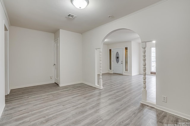 empty room featuring crown molding and light hardwood / wood-style flooring