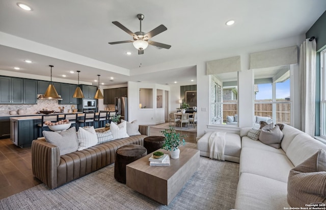 living room featuring hardwood / wood-style floors and ceiling fan