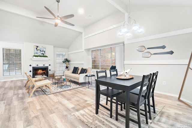 dining area featuring lofted ceiling with beams, light hardwood / wood-style floors, and ceiling fan with notable chandelier