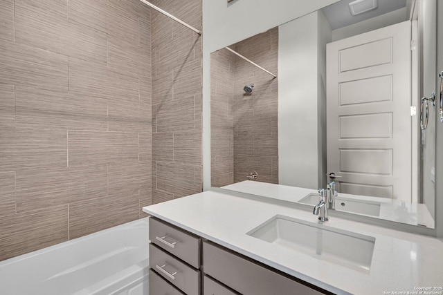 bathroom featuring tiled shower / bath combo and vanity