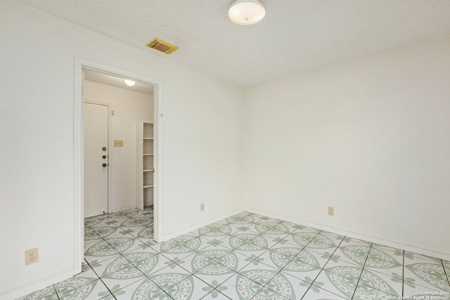 unfurnished room featuring a textured ceiling