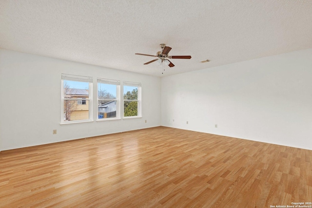 empty room featuring light wood-type flooring and a textured ceiling