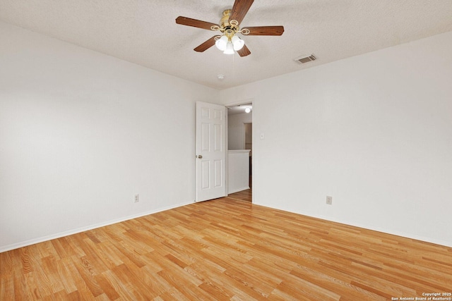 empty room featuring a textured ceiling, light wood-type flooring, and ceiling fan