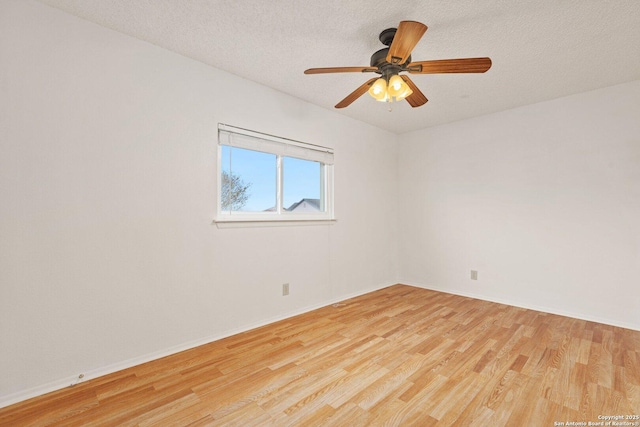 spare room with a textured ceiling, ceiling fan, and light hardwood / wood-style flooring